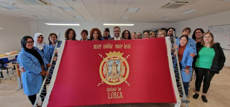 Las alumnas del curso de ‘Perfeccionamiento de bordado’ finalizan una gran bandera de Lorca que presidirá los actos protocolarios del municipio